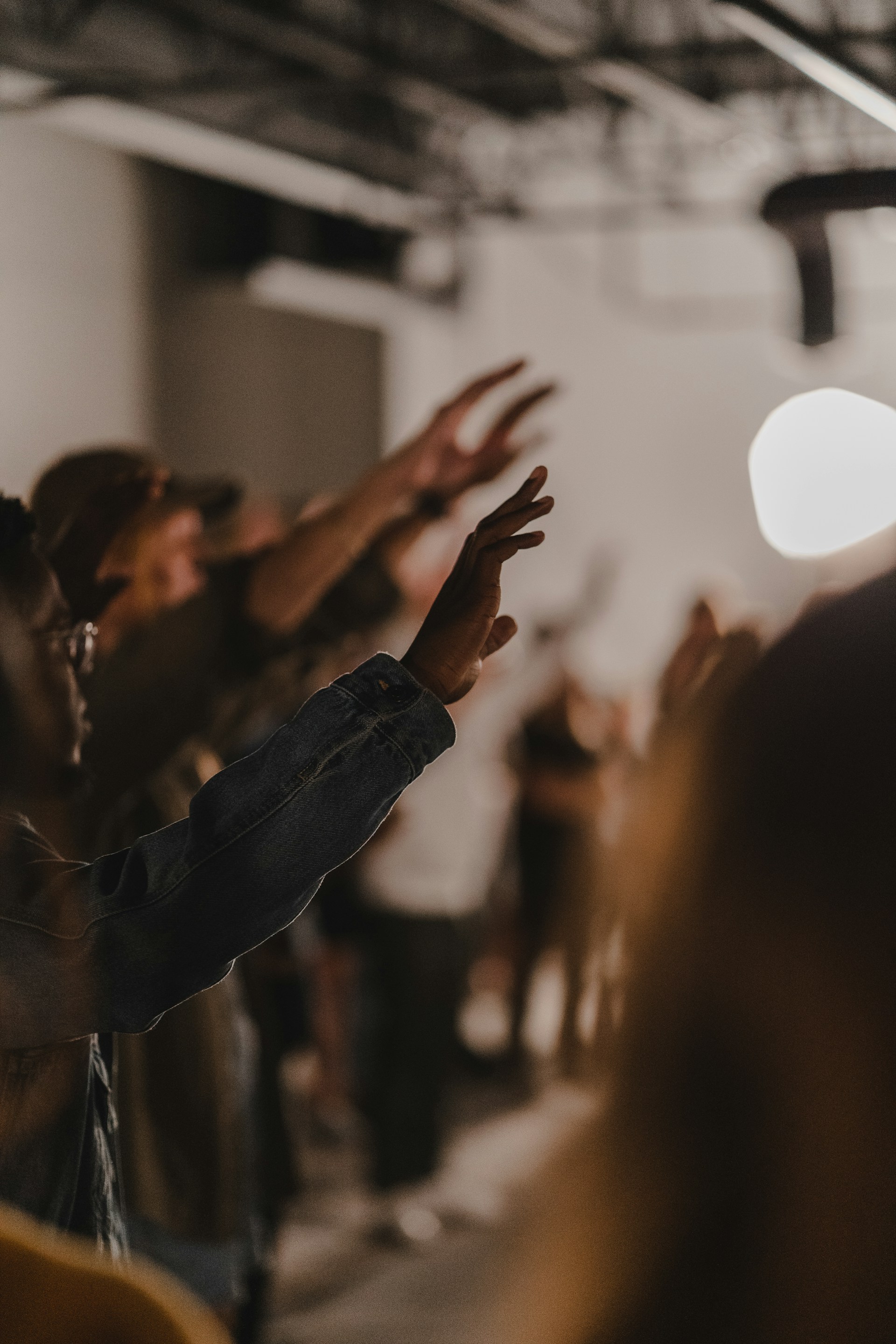Congregation in church with raised hands in worship